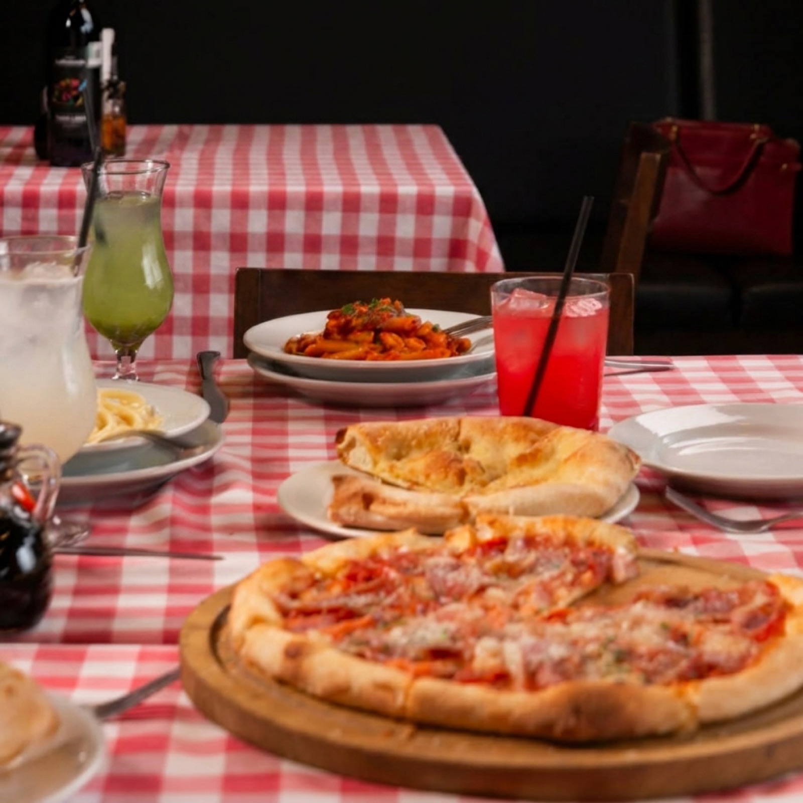 Mesa compartida con pasta, pizza y bebidas en Via Ditalia